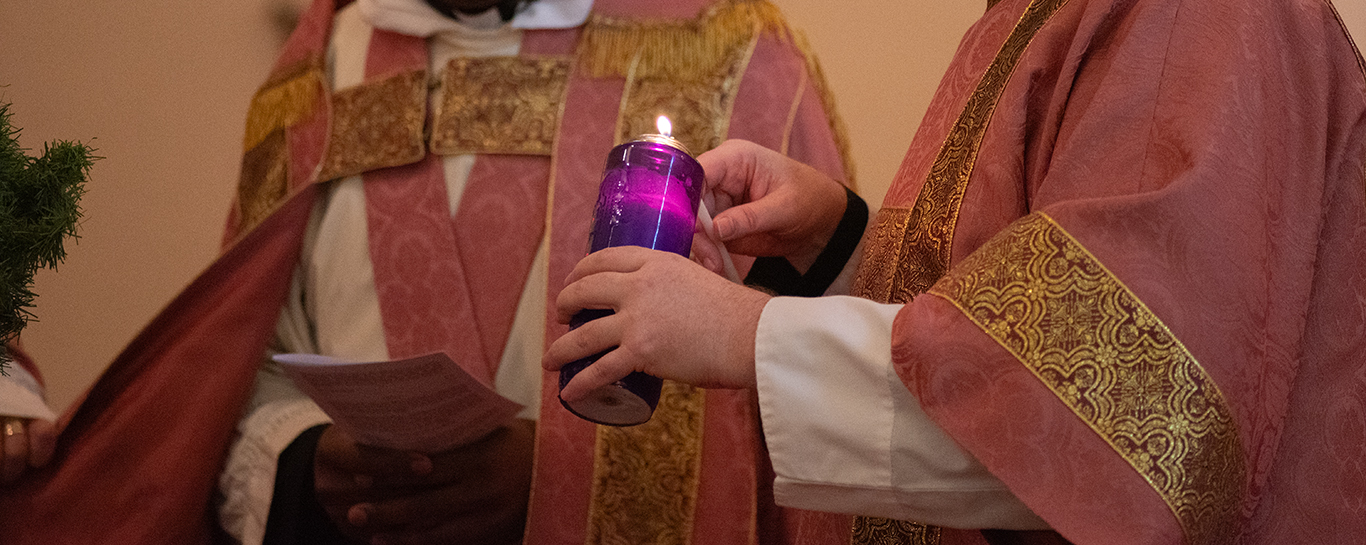 A server lights an advent candle during Advent III