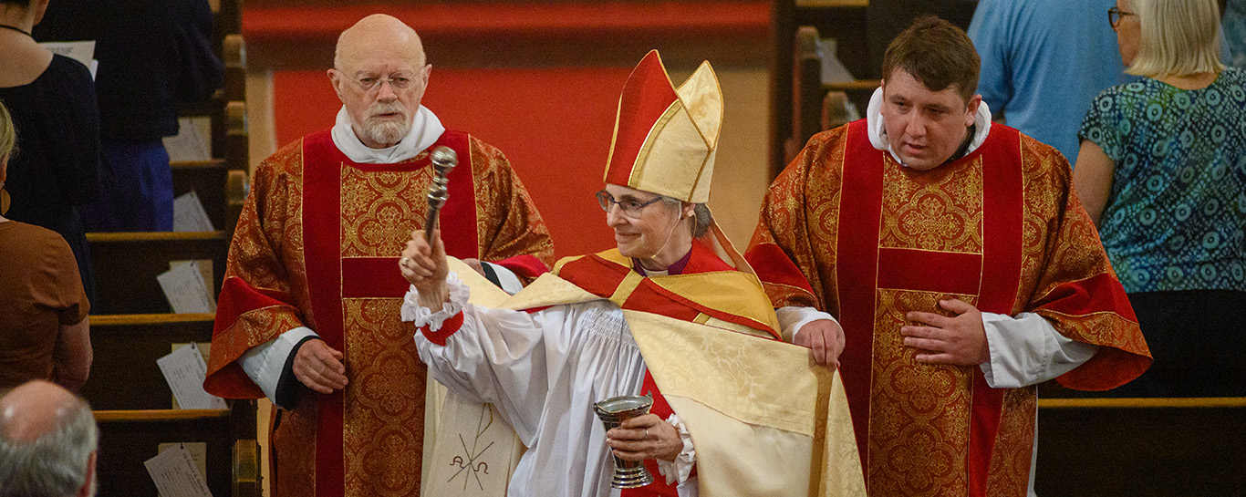 Bishop Kathryn Otley sprinkles holy water on the congregation during the opening hymn