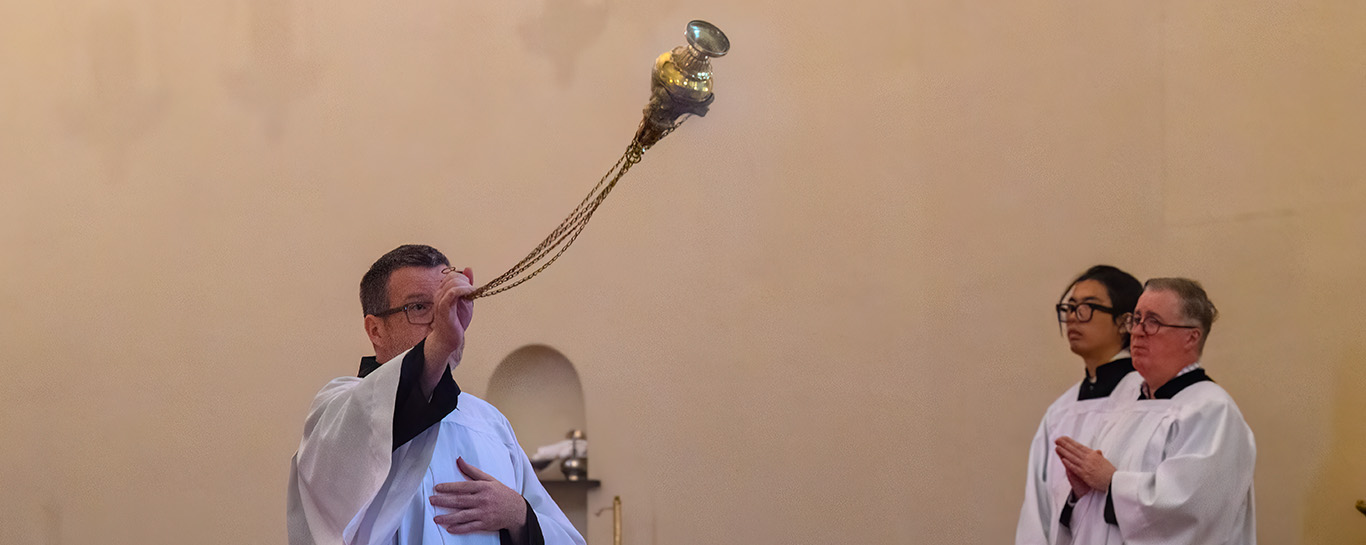 A thurifer censes the congregation