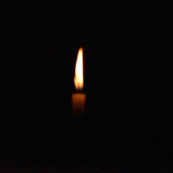 Out of focus candle on a black background