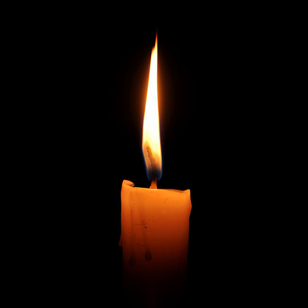 A lit candle in darkness