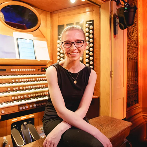Anna Lapwood sitting in front of an organ console