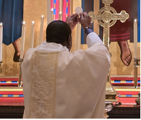 Fr Kwari elevates the Host.