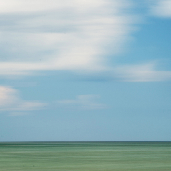 A long exposure of clouds and a lake on a summer's day