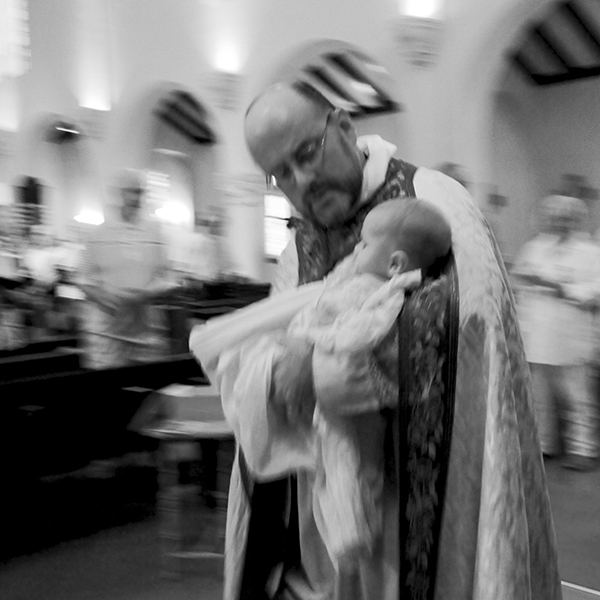 Fr Murray holding a baby just after a baptism