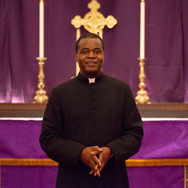 Fr George Kwari in front of the altar arrayed in purple for Advent